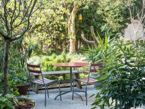 a table and chairs in a garden with trees at Apartments Spalenring 10 in Basel