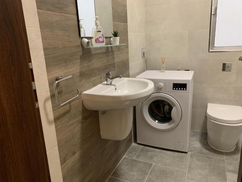 a bathroom with a sink and a washing machine at Large apartment close to rocky beach MCRE1-1 in Sliema