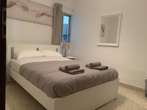 1 dormitorio con 1 cama con 2 toallas en Large apartment close to rocky beach MCRE1-1 en Sliema