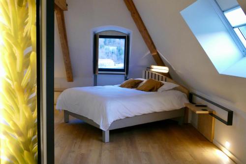 a bedroom with a white bed with a window at Logis Hotel le France in Villers-le-Lac