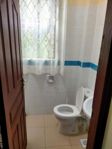 a bathroom with a toilet and a sink at Sunset Fastcare luxury Apartments in Mombasa