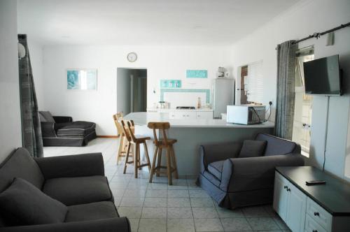 a living room with two couches and a kitchen at Pelican Accommodation Ottery in Cape Town