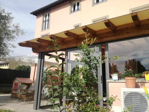 a screened in porch with a roof on a house at BeB La Rosa Nel Verde in Lucca