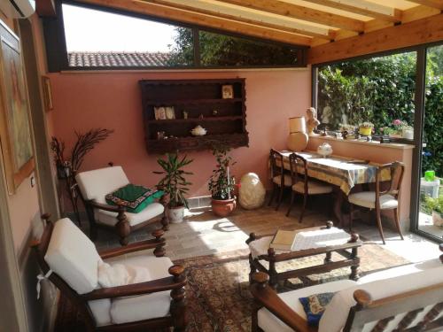 a screened in porch with a table and chairs at BeB La Rosa Nel Verde in Lucca