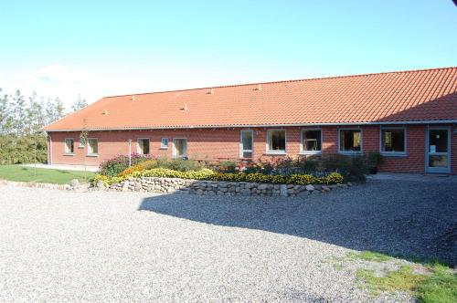 a red brick building with a landscaping in front of it at Nordgården Pension in Onsbjerg