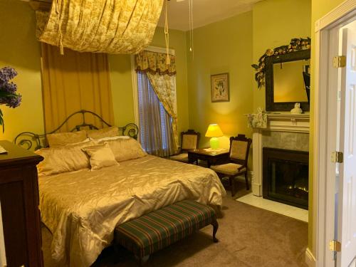 Bayberry House Bed and Breakfast في Steubenville: غرفة نوم بسرير كبير ومدفأة