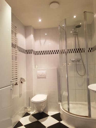 ein Badezimmer mit Dusche, Toilette und Waschbecken in der Unterkunft Appartement "Zicht op de Vuurtoren" in Noordwijk aan Zee