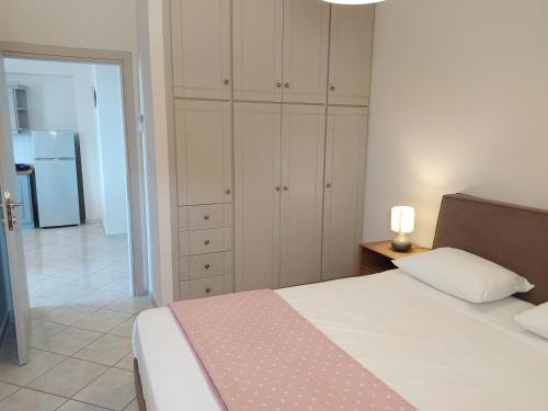 a bedroom with a bed and cabinets and a refrigerator at Blue Yard Apartments in Kalamata