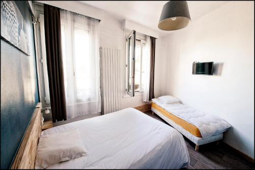 1 dormitorio con 2 camas y ventana en Hôtel du Nord, en Sainte-Geneviève
