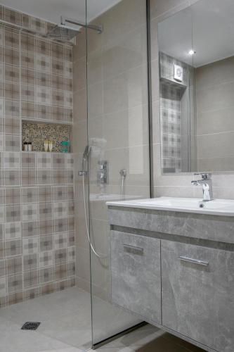 a bathroom with a glass shower and a sink at Athens Starlight Hotel in Athens