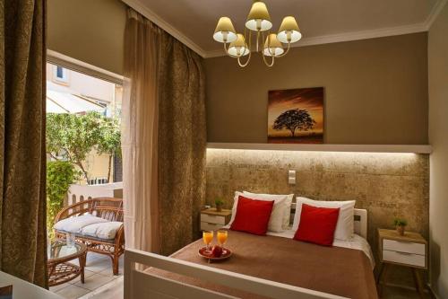 a bedroom with a bed with red pillows and a balcony at Natasha's Luxury apartment by the sea in Galatás