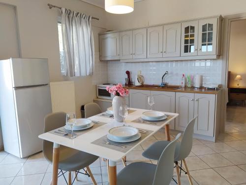 a kitchen with a table with chairs and a white refrigerator at Blue Yard Apartments in Kalamata
