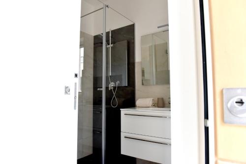 ein Bad mit einer Dusche und einem Waschbecken in der Unterkunft Geranio Apartment - Villaggio di Mary in Locorotondo