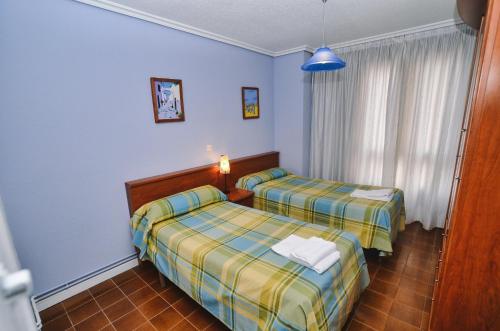 2 camas en una habitación con paredes azules en Perez del Molino - 5806, en Isla