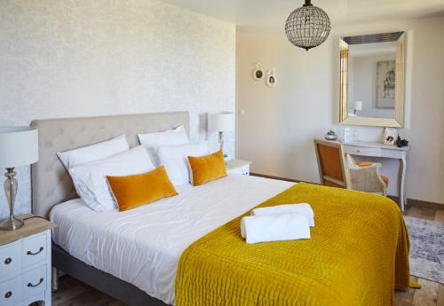 a bedroom with a large bed with a yellow blanket at Domaine de la Fauvriere in Sainte-Honorine-de-Ducy