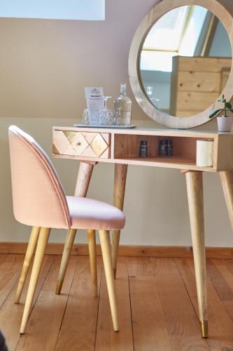 a dressing table with a chair and a mirror at Domaine de la Fauvriere in Sainte-Honorine-de-Ducy