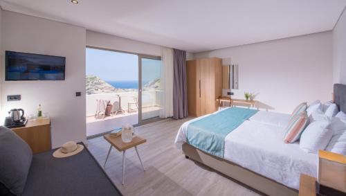 a bedroom with a bed and a view of the ocean at Athina Palace Resort & Spa in Agia Pelagia