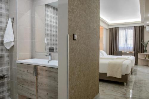 una camera d'albergo con letto e lavandino di Athens Starlight Hotel ad Atene