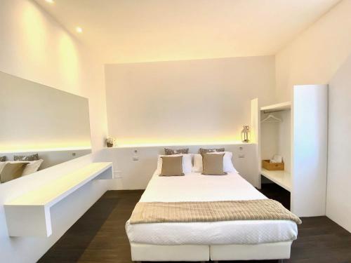 a bedroom with a large white bed and shelves at Soggiorno Lo Stellino in Siena