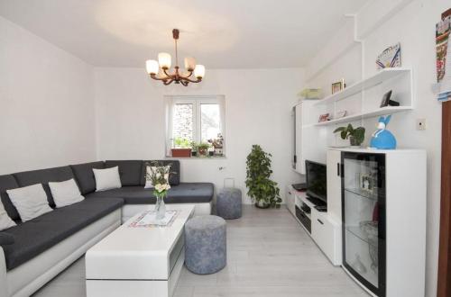een woonkamer met een zwarte bank en een tv bij Apartment Villa DD in Supetar