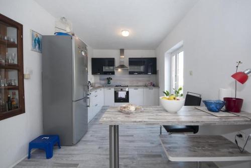 een keuken met een tafel en een koelkast bij Apartment Villa DD in Supetar