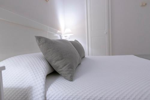 a white bed with a pillow on top of it at Hotel Ramomar in Tomelloso