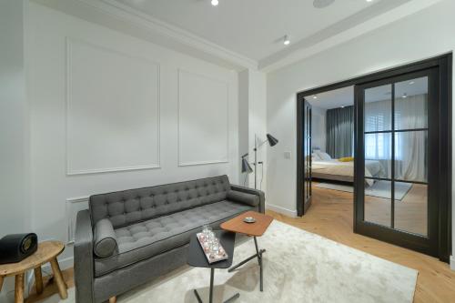a living room with a couch and a mirror at Elysium Residence in Timişoara