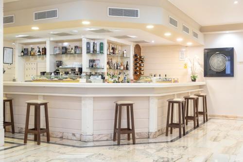 a bar in a restaurant with stools at Hotel Ramomar in Tomelloso