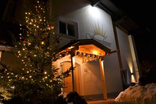 a christmas tree in front of a building at Appartementhaus Sunshine in Achenkirch