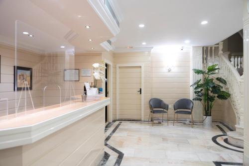 a bathroom with two chairs and a counter with a sink at Hotel Ramomar in Tomelloso