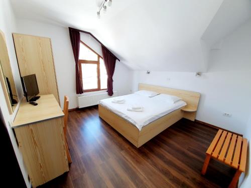 Un pat sau paturi într-o cameră la Vila Alma Azuga