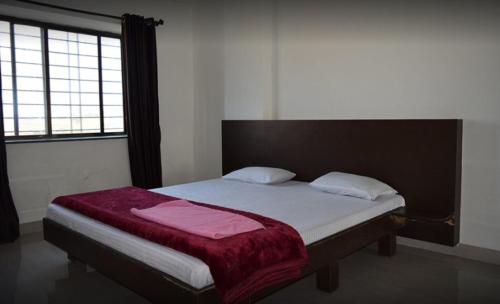 a bedroom with a bed with a red blanket on it at Valley View Igatpuri in Igatpuri