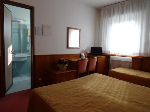 a hotel room with a bed and a bathroom at Hotel Roma in Cividale del Friuli