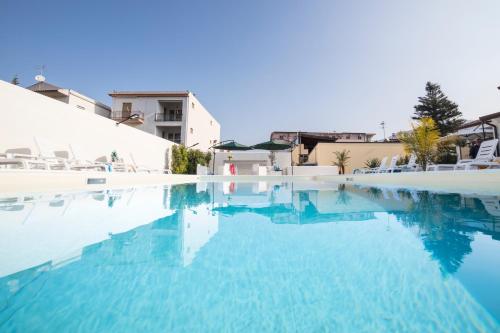una piscina con acqua blu in un resort di Villa Concettina a Capo dʼOrlando