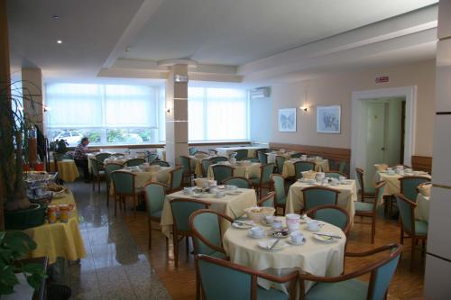 a dining room with tables and chairs and a person at Hotel Roma in Cividale del Friuli