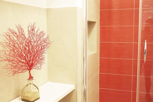La salle de bains est pourvue d'un vase en verre avec un arbre. dans l'établissement Casa Tarantino Charming apartments, à Capri