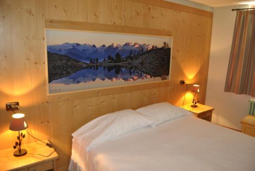 a bedroom with a bed with a painting on the wall at Villa Fridau resort in Gressoney-Saint-Jean