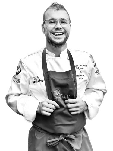 a man in a kitchen uniform holding apron at Hôtel & Restaurant Origines par Adrien Descouls - Teritoria in Issoire