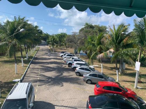 Une rangée de voitures garées sur un parking dans l'établissement Hotel de Trânsito da PM-PE, à Olinda