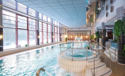 a large swimming pool in a building with windows at Spa Hotel Rauhalahti in Kuopio