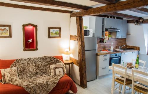 un salon avec un canapé rouge et une cuisine dans l'établissement Maison Le Clos Bartholdi, à Colmar
