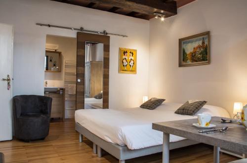 une chambre avec un lit, un bureau et une table dans l'établissement Maison Le Clos Bartholdi, à Colmar