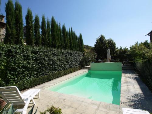 a swimming pool with two chairs and a fountain at Villa La Pergola in Cortona