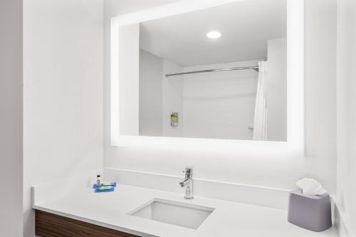 W białej łazience znajduje się umywalka i lustro. w obiekcie Holiday Inn Express Hotel & Suites Palm Bay, an IHG Hotel w mieście Palm Bay