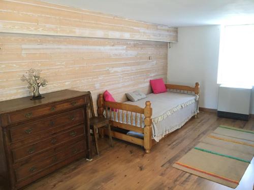 FromentalにあるLa petite maisonのベッドと木の壁がある寝室