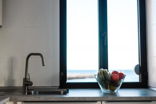 a bowl of fruit on a kitchen counter with a window at Arinaga Colors, tu casa en la playa in Arinaga