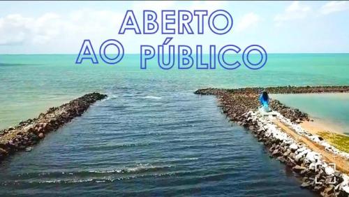 une personne debout sur une plage rocheuse près de l'océan dans l'établissement Hotel de Trânsito da PM-PE, à Olinda