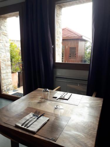 a wooden table with silverware on it in front of a window at Locanda Sensi in Rivergaro