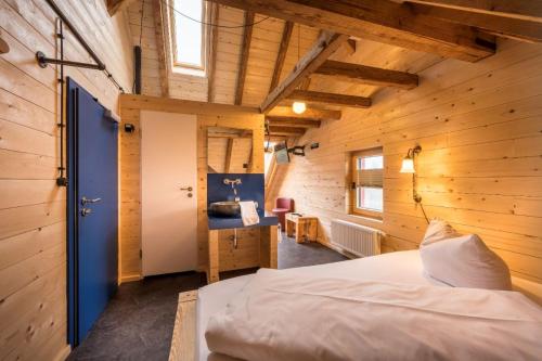 コンスタンツにあるLandgasthof Kreuzの木製の壁のベッドルーム1室、ベッド1台が備わります。