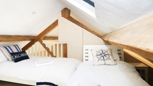 two beds in a attic room with wooden ceilings at Unicorn Cottage in Bakewell